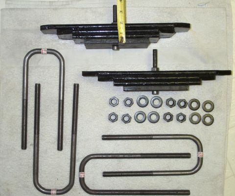 2002 Ford Excursion - This photo displays automotive suspension parts, including leaf springs and U-bolts, along with associated hardware.