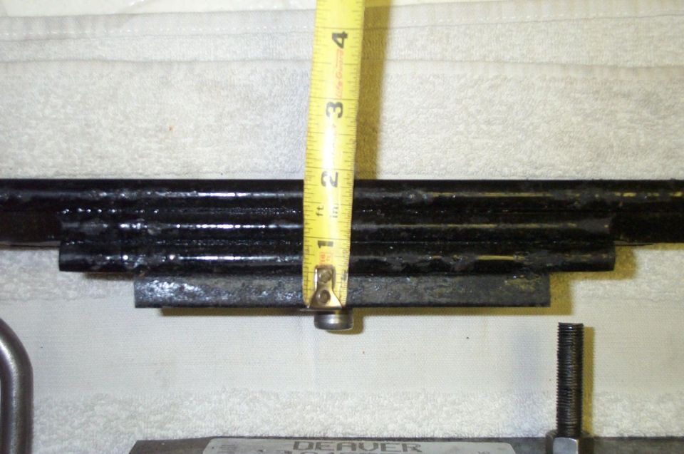 Leaf spring pack measured with yellow tape measure at center bolt