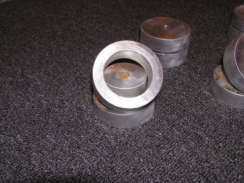 1993 Ford Taurus - Metal spacers are shown stacked on a dark carpeted surface.