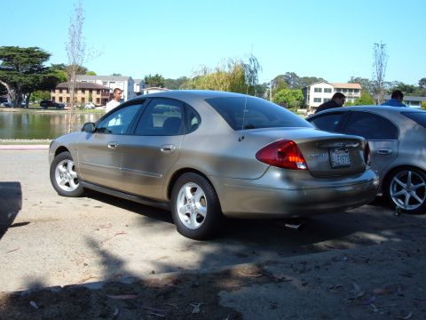 1995 Ford Taurus - Rear view of a gold sedan, possibly a 2000 Ford Taurus, parked outdoors.