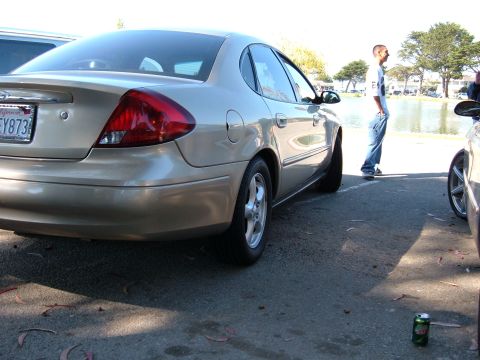1995 Ford Taurus - This gold sedan's taillights and body style suggest a model year around 2000, not 1995.
