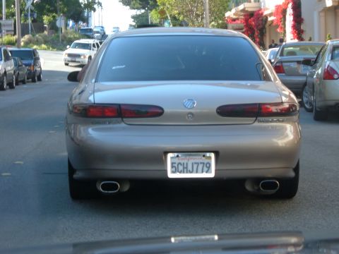1995 Ford Taurus - Tan Mercury Sable sedan seen from the rear on a city street.