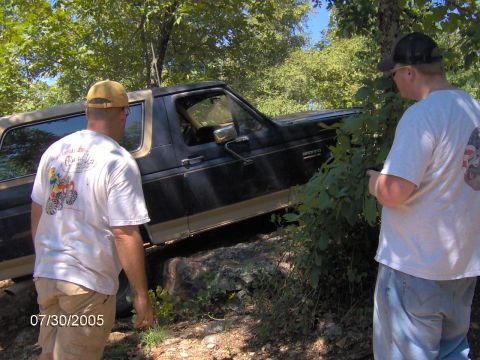 1978 Ford Bronco - A black 1978 Ford Bronco navigates rocky terrain with two onlookers.