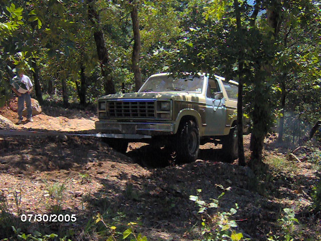 1978 Ford Bronco on a dirt trail, light brown and white paint, off-road tires