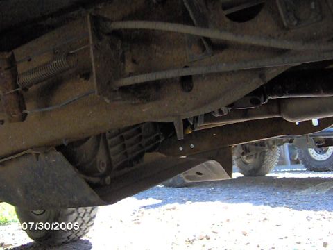 1978 Ford Bronco - Undercarriage detail of a vehicle, with another vehicle partially visible in the background.