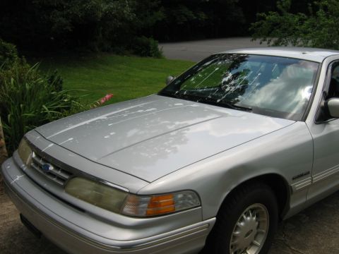1985 Ford LTD Crown Victoria - This 1985 Ford Crown Victoria LTD is shown from the front quarter angle, with white splatters visible on its hood and windshield.