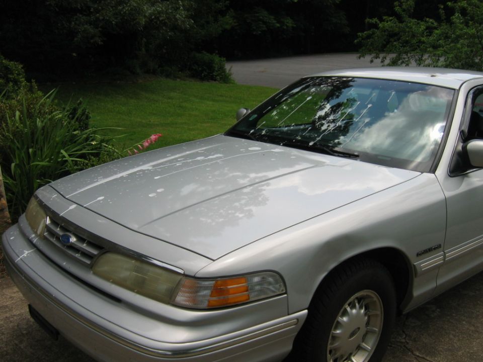 Silver 1985 Ford Crown Victoria LTD front quarter view with white splatters on hood and windshield