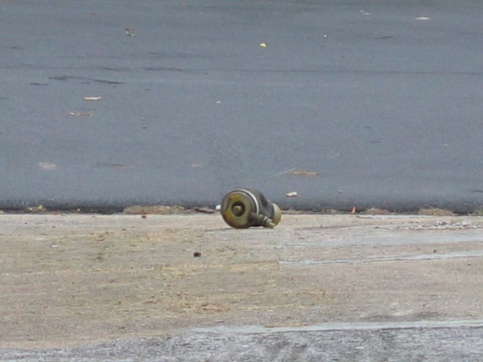 Brass wheel cylinder lying on concrete near asphalt