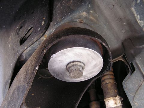 1993 Ford Taurus - A close-up view of a vehicle's subframe mount, a large bolt securing the component.