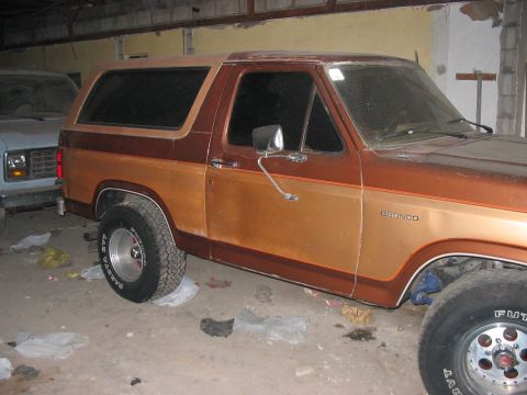 1986 Ford Bronco - Two-tone brown 1986 Ford Bronco parked indoors next to another vehicle.