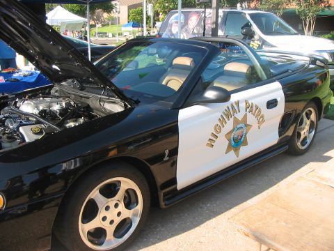 1986 Ford Bronco - This black and white Ford Mustang convertible is marked as Highway Patrol, with its hood open revealing the engine.