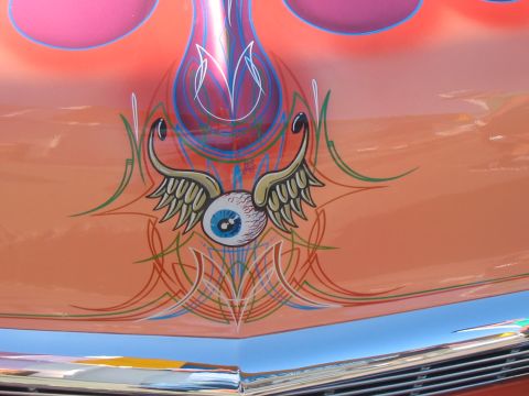 1986 Ford Bronco - A custom painted car hood features a winged eyeball graphic with pinstriping details.