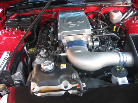 1986 Ford Bronco - Close-up of a modified engine bay, likely a Ford Mustang, a supercharger and custom intake.