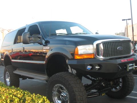 1986 Ford Bronco - This modified Ford Excursion features a prominent aftermarket bumper and elevated suspension system.
