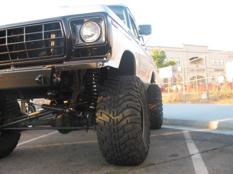 1986 Ford Bronco - This lifted pickup truck features aggressive off-road tires and a prominent front grille.