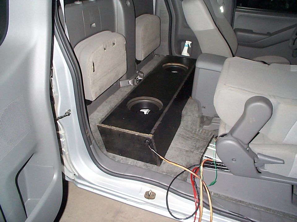 Pickup truck interior showing a custom subwoofer box installed behind the front seats