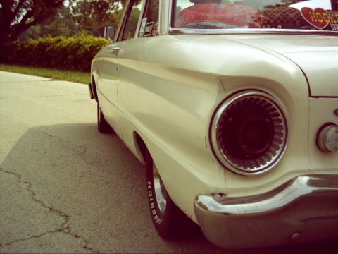 1962 Ford Falcon - The distinctive round taillight and chrome bumper of a 1962 Ford Falcon are visible in this rear quarter view.