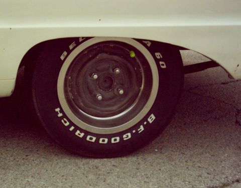 1962 Ford Falcon - The side view of a vehicle's rear wheel and fender shows tire details and a portion of the car's body.