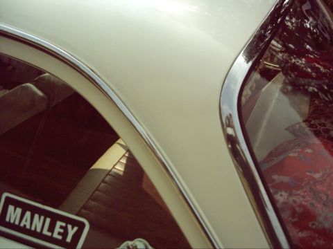 1962 Ford Falcon - A close-up view of a vintage car's interior and exterior trim, showing a "MANLEY" sticker on the window.