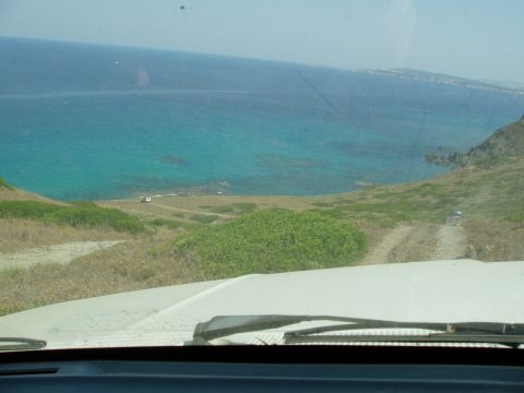 1988 Ford Bronco - Driving on a dirt road overlooking the turquoise ocean on a sunny day.