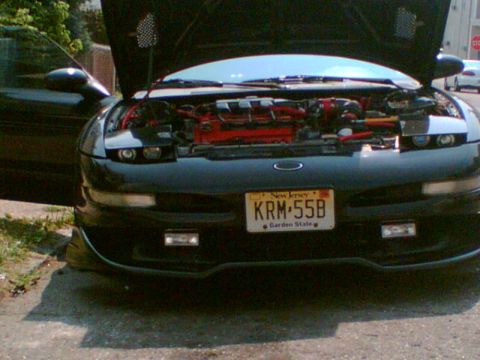 1997 Ford Probe - A black car with its hood open is parked outside, revealing its engine and red accents.