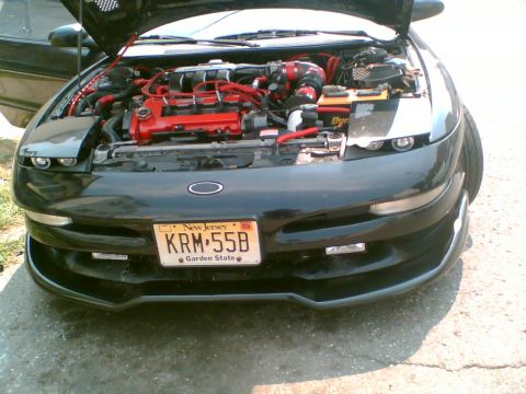 1997 Ford Probe - The engine bay of a black car is visible with custom red accents and a New Jersey license plate.