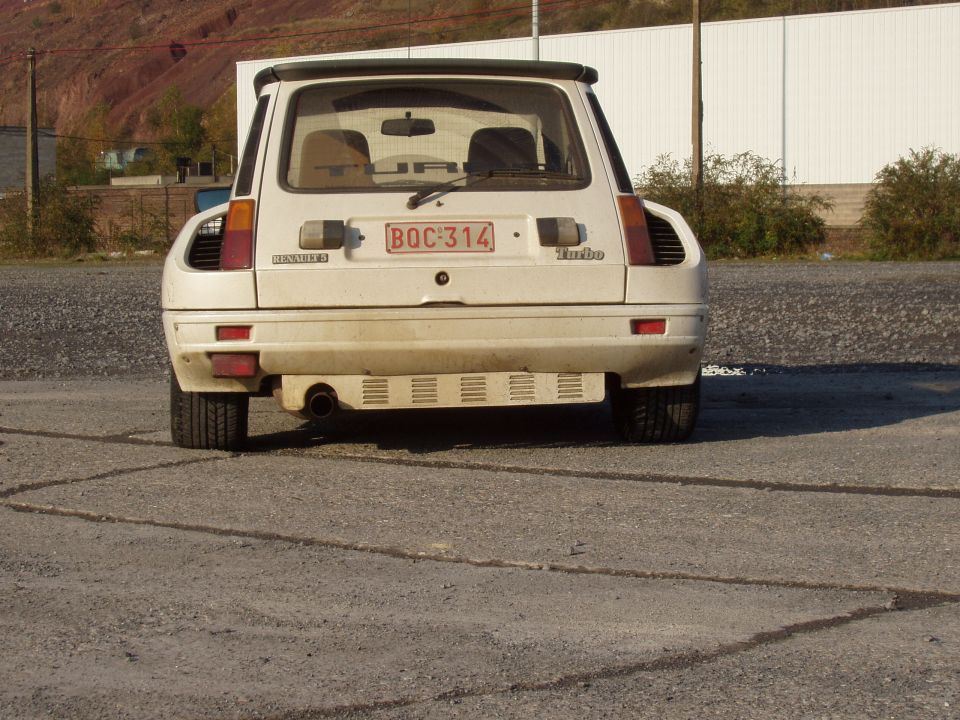 Rear of white Renault 5 Turbo hatchback on cracked asphalt lot