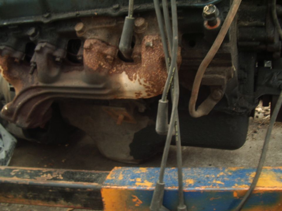 close-up of rusty exhaust manifold and spark plug wires