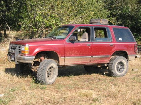 1991 Ford Explorer - Red 1991 Ford Explorer modified for off-road use, parked outdoors.