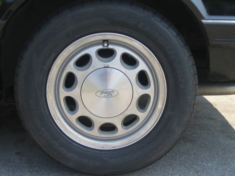 1985 Ford Mustang - A close-up view of a 1985 Ford Mustang's wheel and tire assembly.