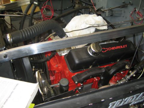 1990 Ford Bronco - red Chevrolet engine block with a black Chevrolet valve cover sits installed in an engine bay above a Toyota panel.