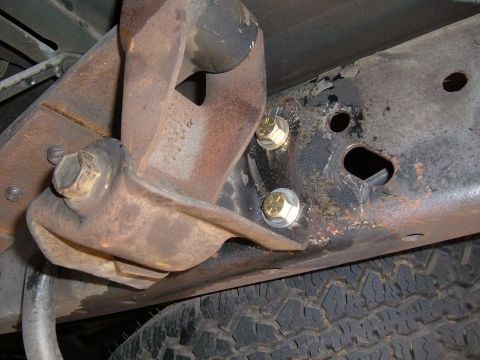 1985 Ford Ranger - Detail of a corroded vehicle frame and suspension components, with a tire in the background.