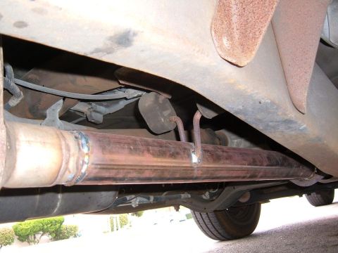 1985 Ford Ranger - Close-up view of the exhaust system and undercarriage components of a vehicle.