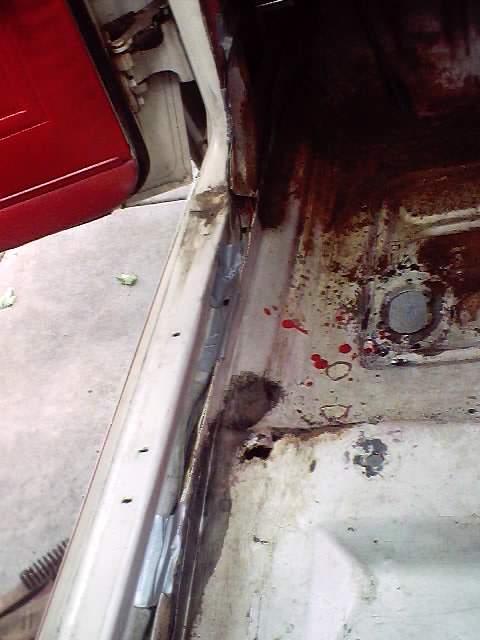 1966 Ford Fairlane - Interior view of a 1966 Ford Fairlane's floor pan and door jamb, revealing rust and damage before restoration.