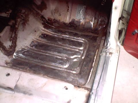 1966 Ford Fairlane - The floor pan of a vehicle shows significant rust and wear, indicating a need for restoration.