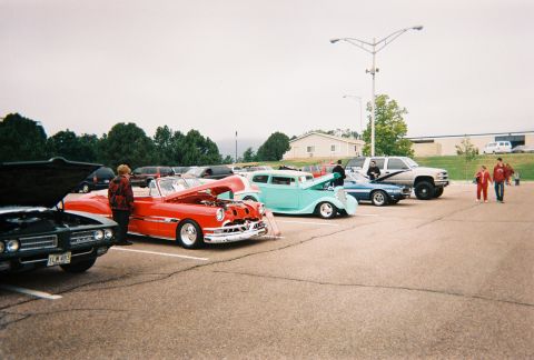 1972 Ford Ranchero - Several vintage cars are displayed at an outdoor event, with people milling around.