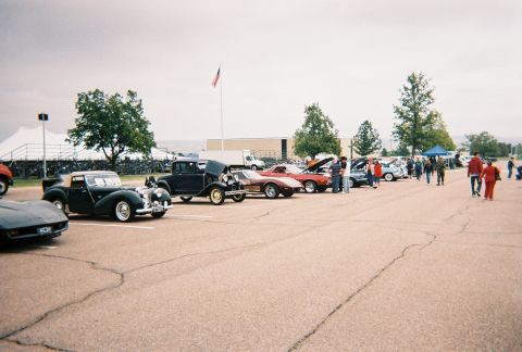 1972 Ford Ranchero - A dark green convertible classic car is parked among other vehicles at an outdoor event.