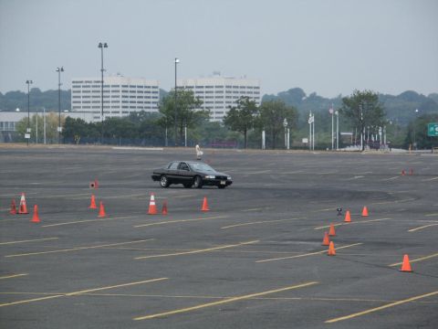 2001 Mercury Grand Marquis - A black 2001 Mercury Grand Marquis navigates a cone course in a large, empty parking lot.