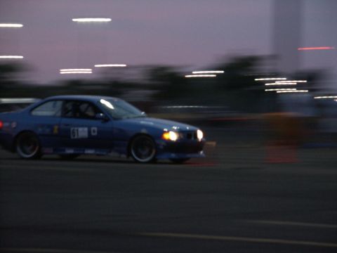 2001 Mercury Grand Marquis - A blue coupe with racing decals drifts on a track at dusk.