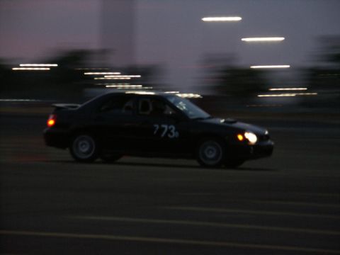 2001 Mercury Grand Marquis - A black sedan with racing numbers is seen in motion at dusk.
