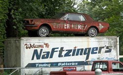 1978 Ford Mustang II - A vintage Ford Mustang coupe is displayed on top of a towing company's truck.