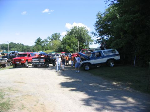 1986 Ford Bronco - A blue and white 1986 Ford Bronco is displayed at a truck show with its hood up.