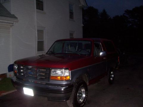 1994 Ford Bronco - 1994 Ford Bronco parked in front of a house at dusk.