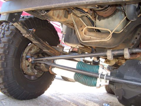 1990 Ford Bronco - Undercarriage view of a 1990 Ford Bronco, showing its suspension and large off-road tires.