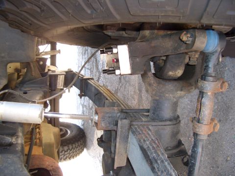 1990 Ford Bronco - The underside of a 1990 Ford Bronco reveals its robust suspension system, including leaf springs and shock absorbers.