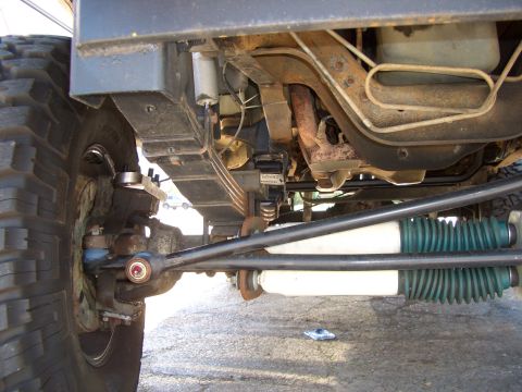1990 Ford Bronco - Close-up of the undercarriage, focusing on the suspension and steering systems of a vehicle.