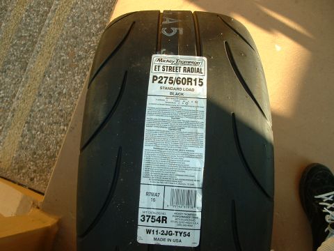 1992 Ford Crown Victoria - New Mickey Thompson ET Street Radial drag tire lying on a concrete floor, still wearing its factory spec label reading P275/60R15 standard…
