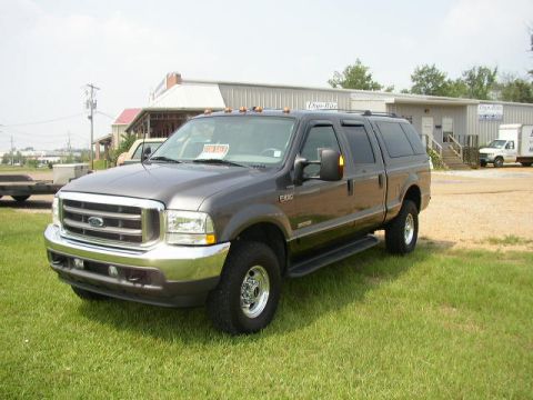 1995 Ford Bronco - This Ford F-250 Super Duty truck is shown with a cap, parked outside a commercial building.