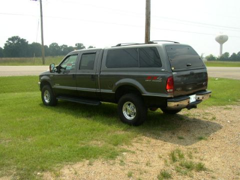 1995 Ford Bronco - This crew cab pickup truck features a camper shell and a "4x4 OFF ROAD" decal on the fender.
