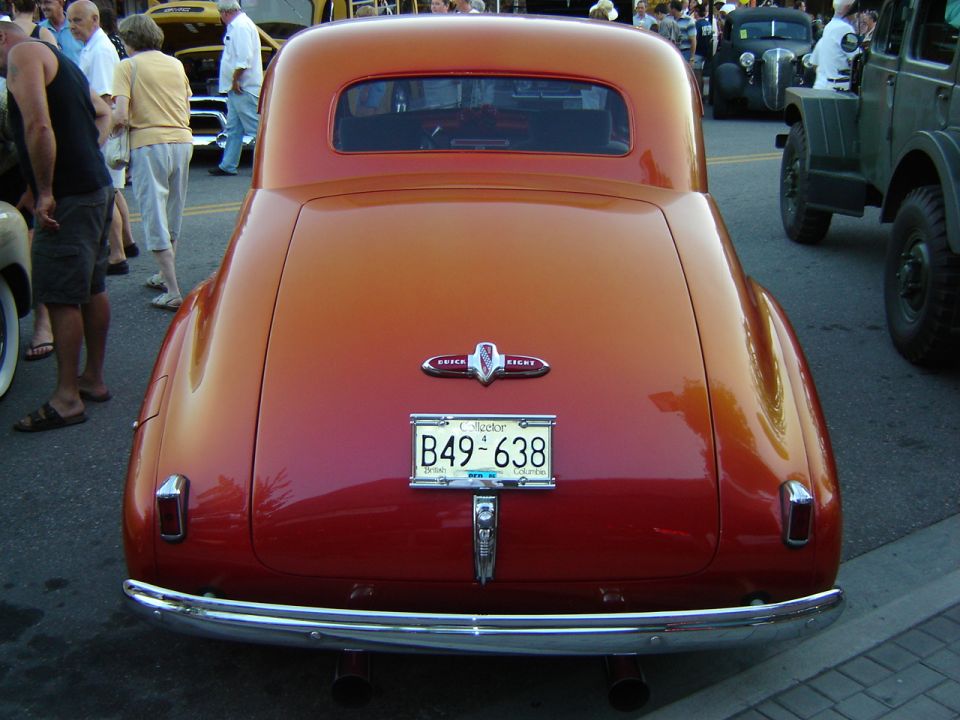 Rear view of a red Buick coupe with a chrome bumper and dual exhaust. License plate B49-638 is visible